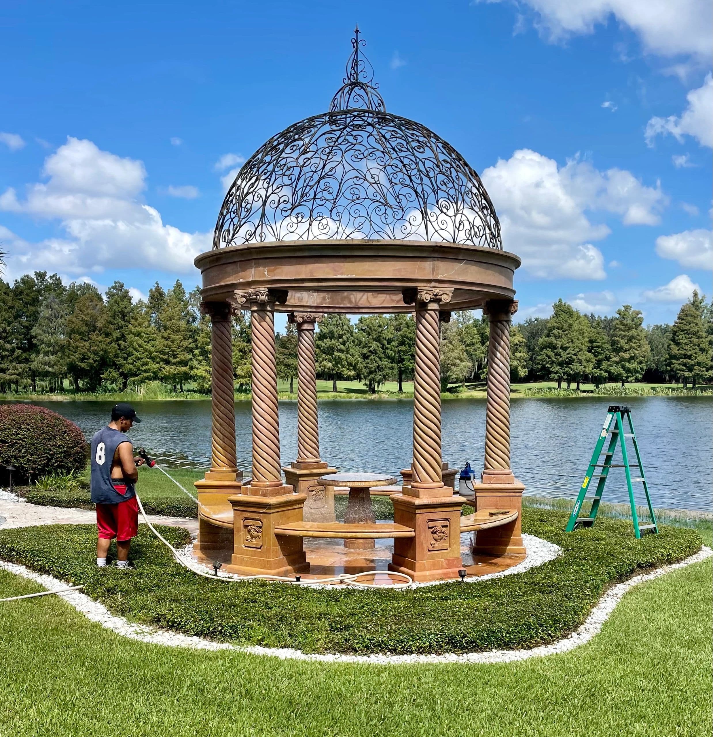 Best Cleaning & Restoration team member pressure washing an ornate stone fountain gazebo
