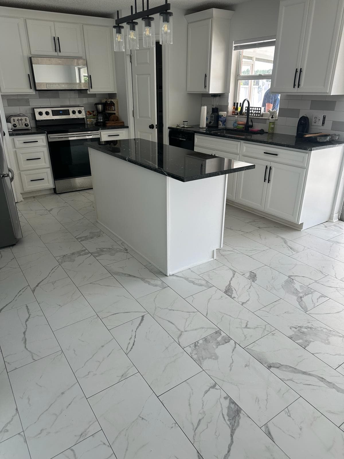 Finished kitchen with new large-format tile flooring by Best Cleaning & Restoration