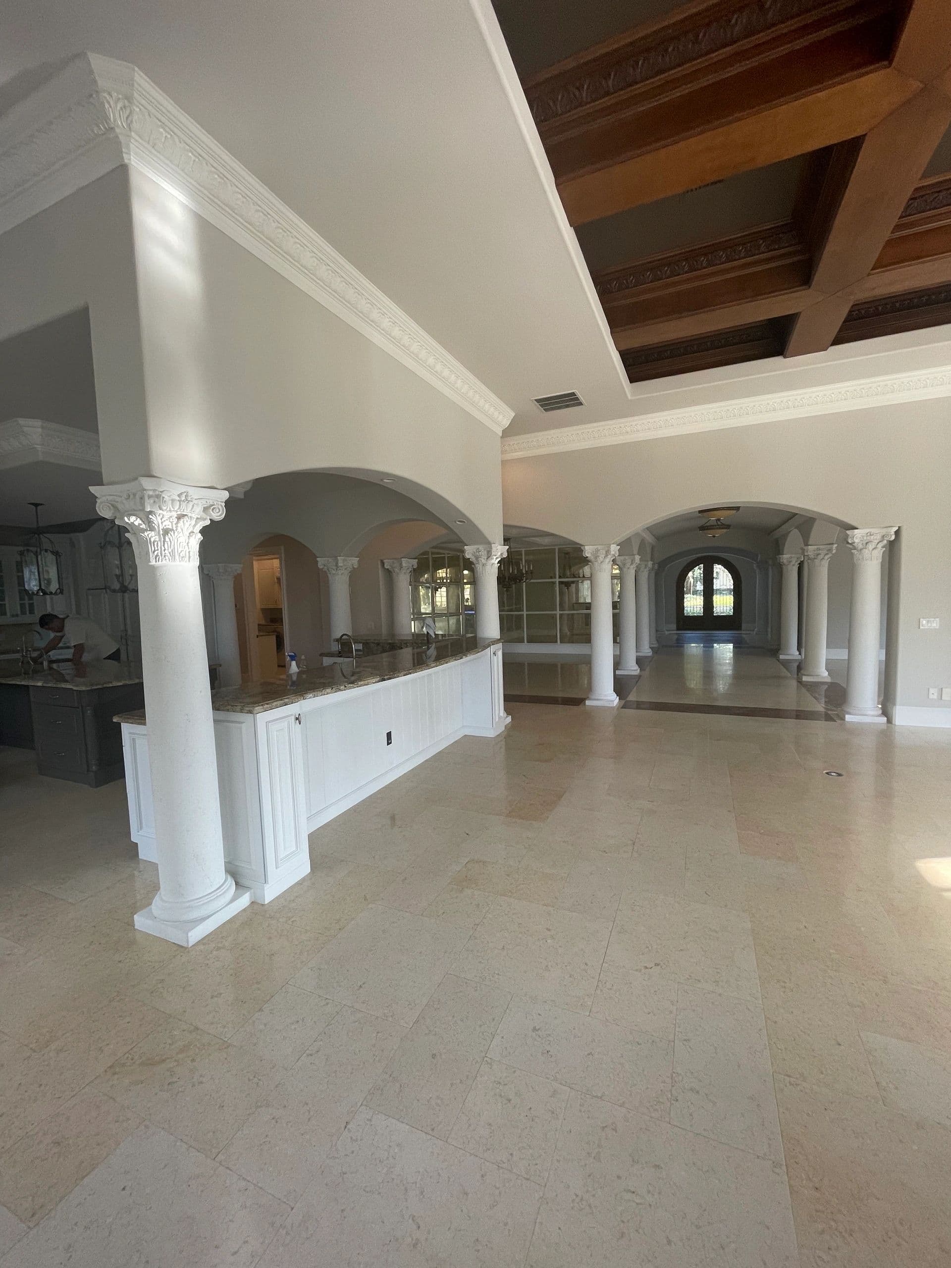 Grand tiled hallway with columns and vaulted wood-beam ceiling