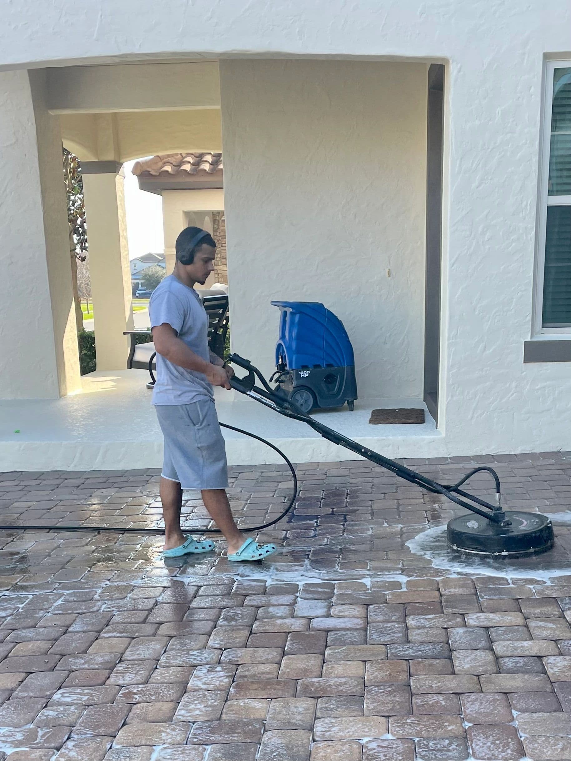 Best Cleaning & Restoration team member cleaning a paver patio