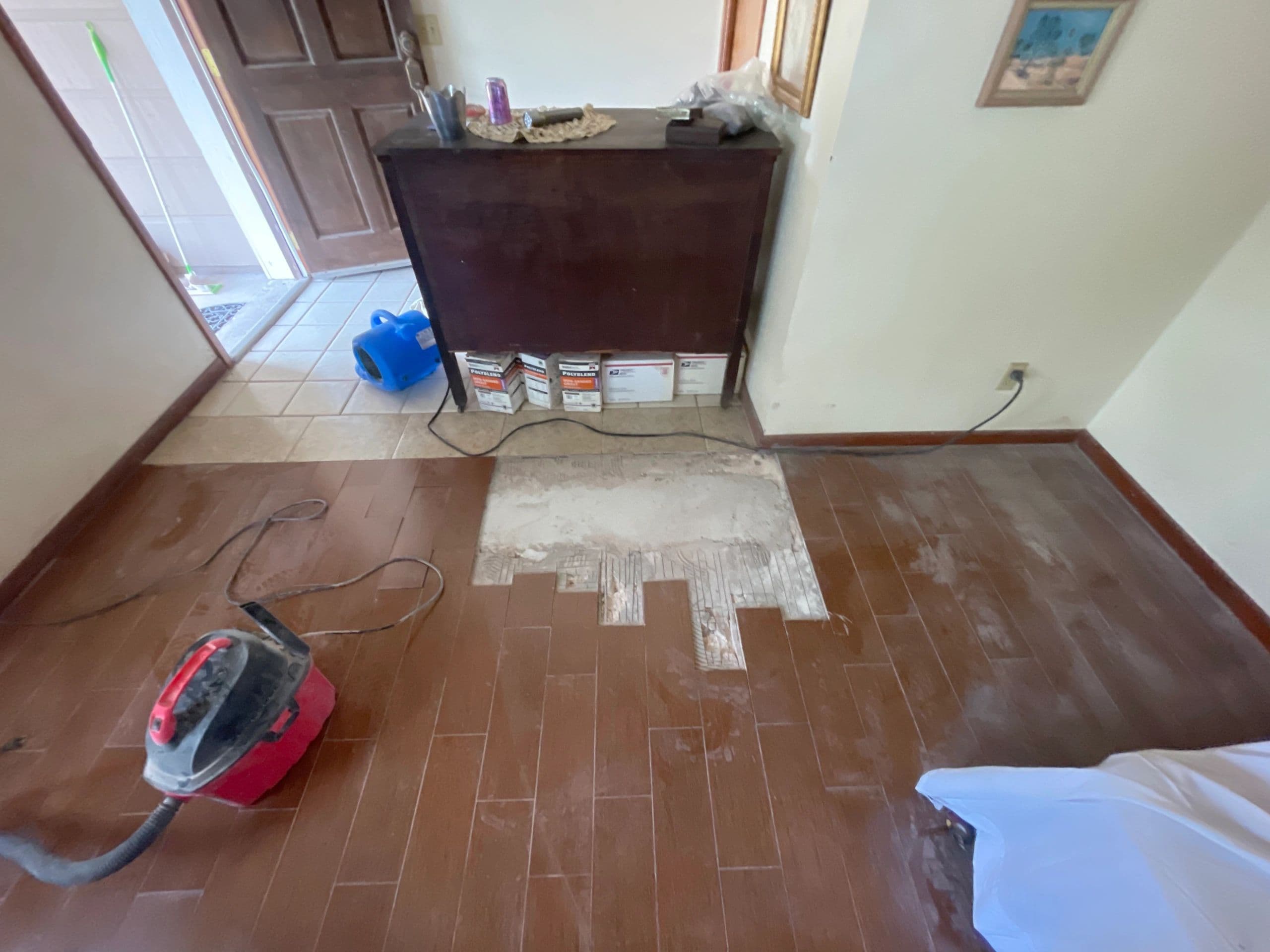 Water damage restoration in progress, flooring removed and drying equipment running