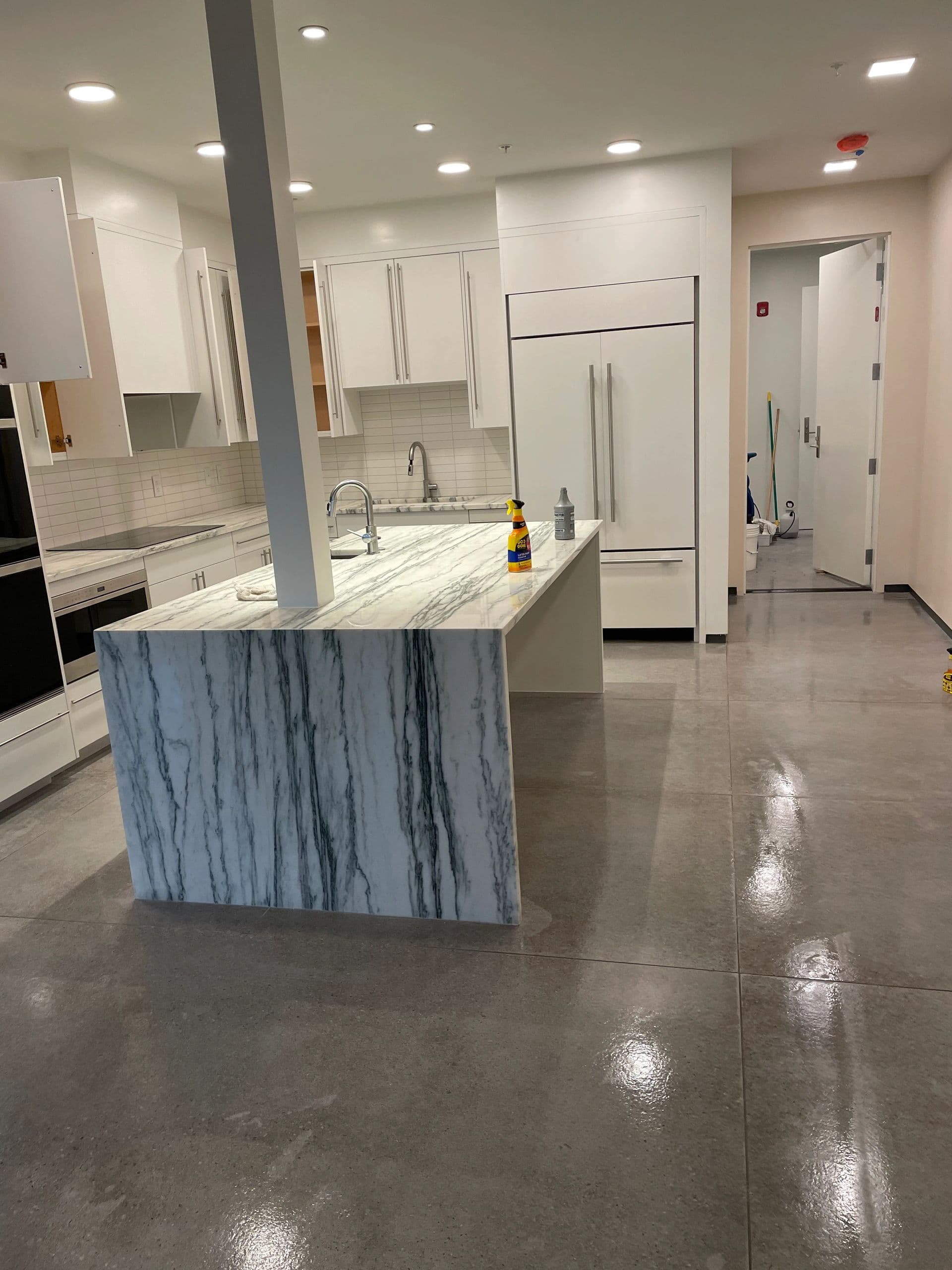 Modern kitchen with marble island and polished concrete floor